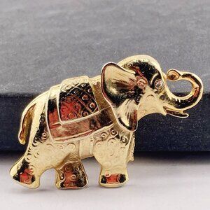 VINTAGE Embossed gold tone metal elephant brooch with rhinestone eye animal pin